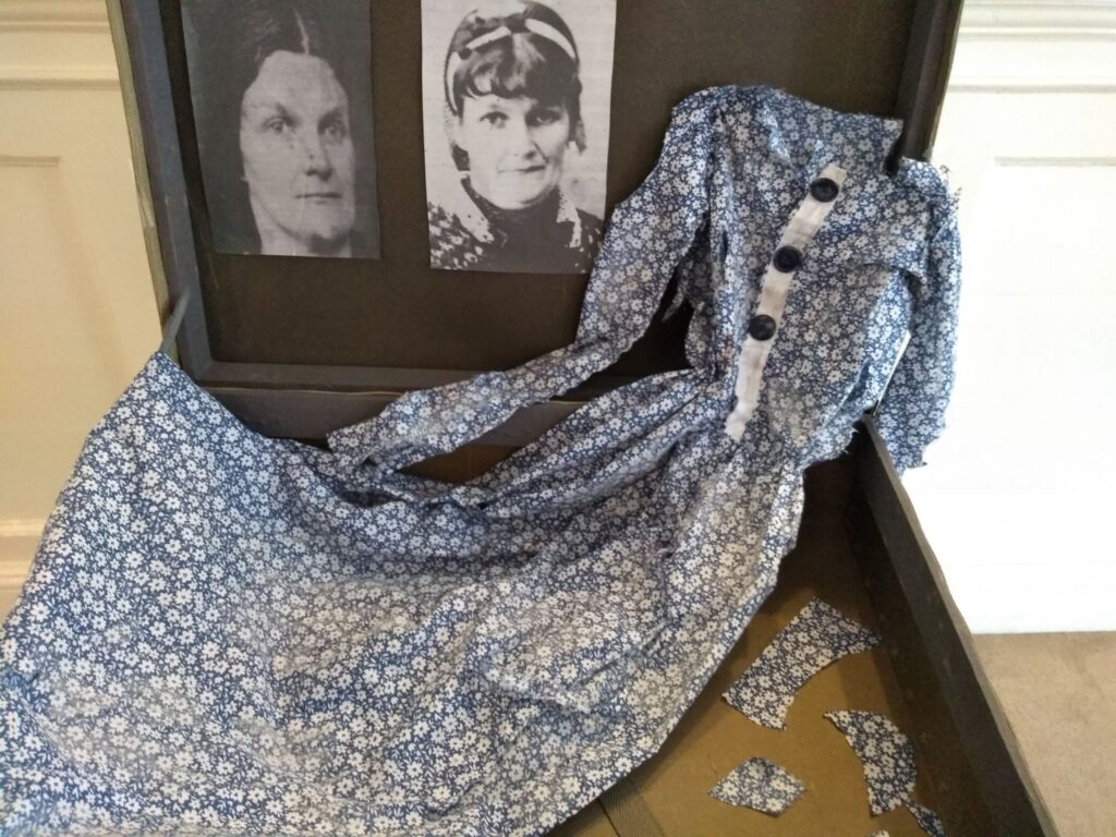 An open suitcase displaying two images of the same woman and a torn blue and white dress.